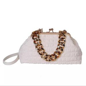 Large size women's handbag with gold chunky chain handle.